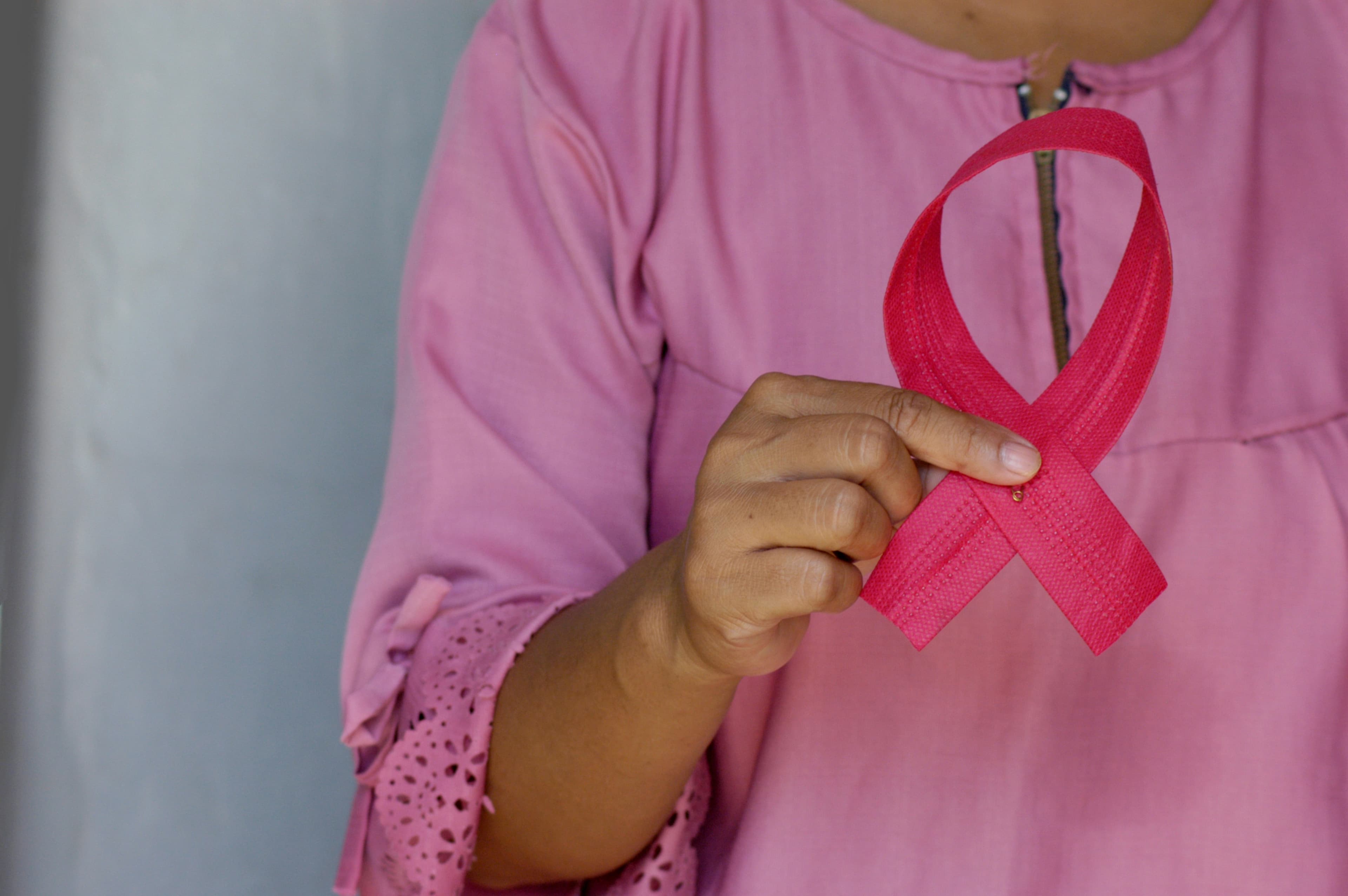 Woman holding Breast Cancer symbol
